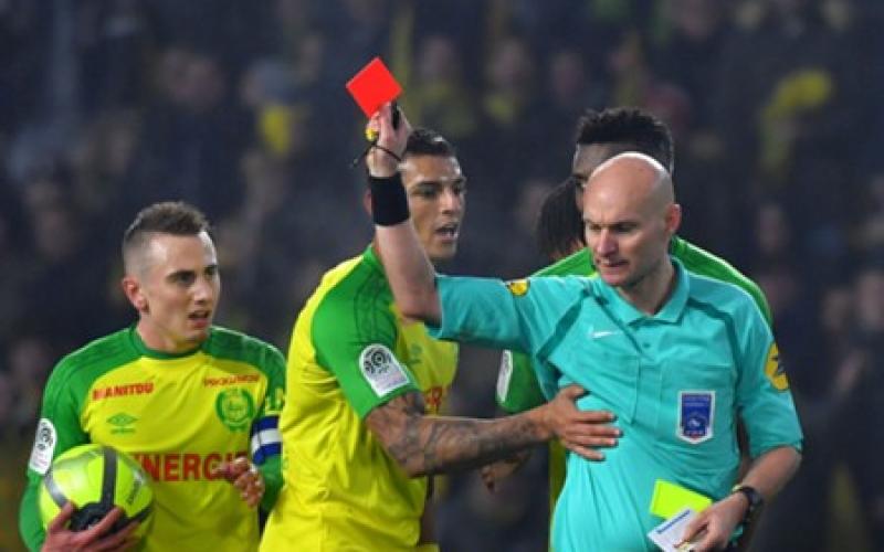 L'arbitre Tony Chapron tacle un joueur avant de l'exclure lors du match Nantes-PSG
