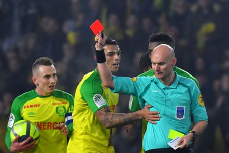 L'arbitre Tony Chapron tacle un joueur avant de l'exclure lors du match Nantes-PSG